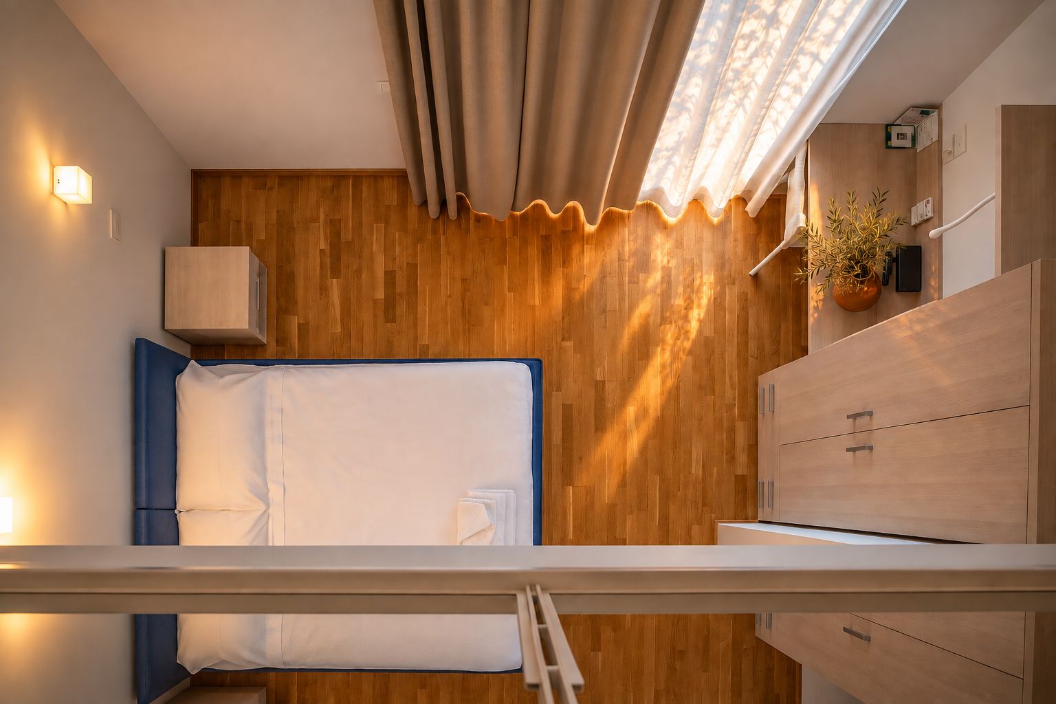Camera duplex dell'ASC Hotel ad Arezzo vista dal soppalco, con la luce del pomeriggio sul parquet